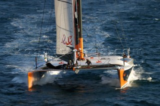 Maxi catamaran Orange skippered by Bruno Peyron crossing the startline of the Jules Verne