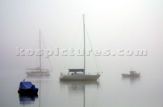 Yachts in the fog and mist on the River Dart in Devon