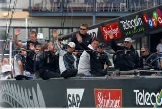 Crew members onboard Team New Zealands NZL-82 wave at fans before race four of the Americas Cup in Auckland, New Zealand. Feb, 25. 2002. Alinghi Swiss Challenge lead Team New Zealand 3-0 in the best of nine races.