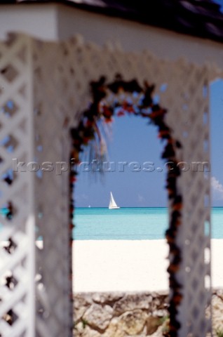 Boat through arch on sandy beach  Antigua