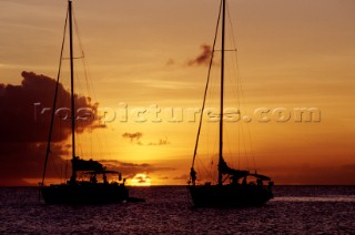 Two anchored yachts at sunset.