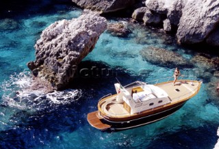 Anchored classic power boat in seclude bay.