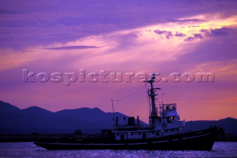 Tug boat in the port of Cagliari Sardinia during a dramatic sunset 