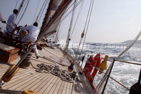 Helmsman steers classic yacht Eleanora through choppy seas at Les Voiles de Saint Tropez France