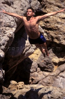 Musto man high diving into the sea from a cliff in Majorca