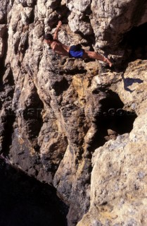 Musto man high diving into the sea from a cliff in Majorca