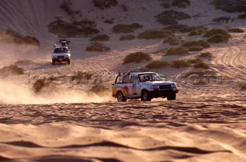 Two trucks drive in convoy through the desert Dubai  United Arab Emirates 