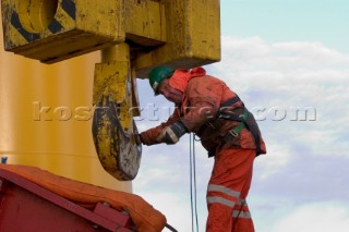 Construction of Windfarm on the Kentish flats in the Thames estuary off Whitstble Kent. Onboard the construction ship Resolution during the foundation process, where the Monopile is hammered in to the seabed with a hydraulic hammer and the transition piece lowered onto the monopile, picture shows monopile being craned into place ready for piling into seabed