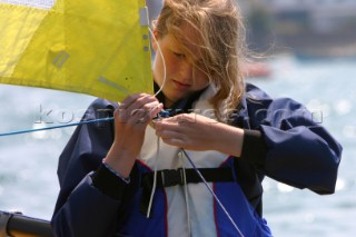 Young girl tying sheet to the clew of a sail