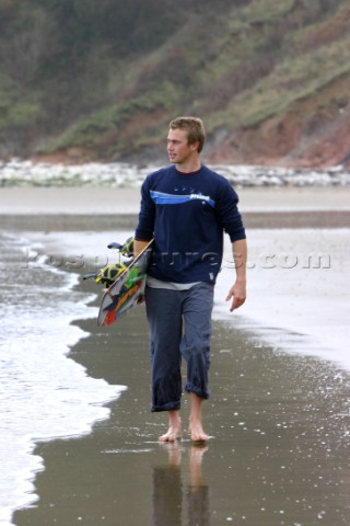 Man walking along Whitecliff Bay Beach with Kiteboard Isle of Wight