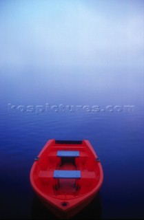 Red boat floating on Hawkesbury river on a misty morning light