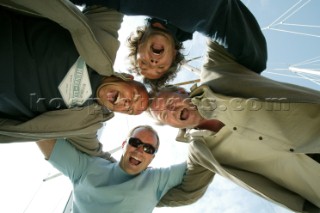 Four men forming a circle looking down at camera