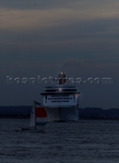 P&O cruise ship Aurora with navigation lights at night turning sharply to avoid collision with a small sailing yacht in restricted waters