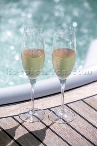 Two glasses of champagne by the side of a jacuzzi