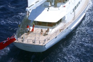 Guests and crew on aft deck of sailing superyacht