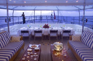 Table laid for dinner on the aft deck of superyacht