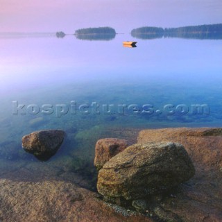 Boat on still water off rocky shore