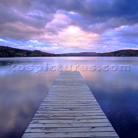 Wooden jetty on lake at sunset