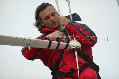 Sailor checking rigging on sailing yacht