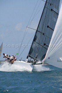 Swan yachts racing behind wave in rough seas