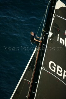 Sailor climbing mast on Open 60