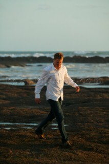 Male model walking on beach in casual wear