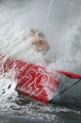 Skipper of the Open 60 Ocean yacht Alex Thomson gets a soaking on the bow in rough seas