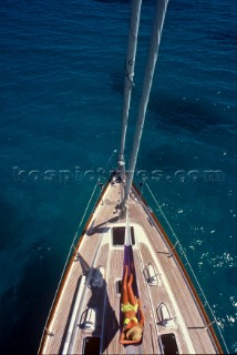 Girl relaxing in hamock on forececk of anchored superyacht