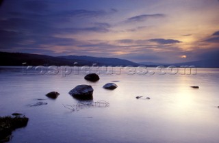 Still water of Loch Lomond at sunset