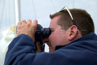 Man looking through binoculars on board Gipsy Moth