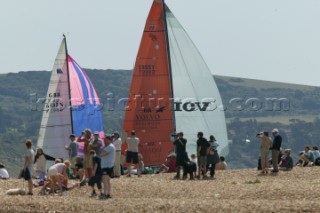 The Fasntet fleet pass through the Solent by Hurst Castle watched by a crowd on the beach.