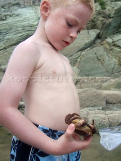 Children playing on a sandy beach looking for crustacea and crabs