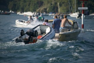 Holidaymakers and tourists towing an inflatable dinghy with launching wheels and trolley attached