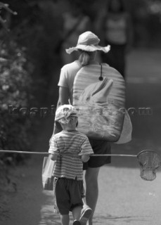 Lady and young boy heading for beach with boogy board and fishing net