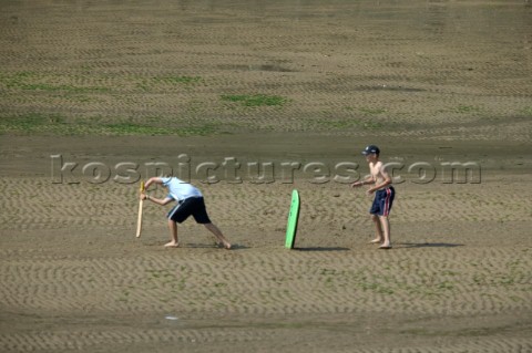 Boys playing cricket on beach at Salcombe Devon