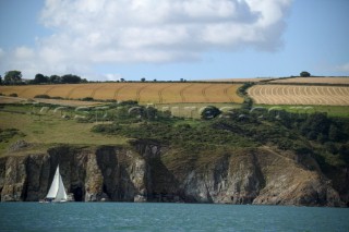 Cruising yacht sailing along the Devon coast