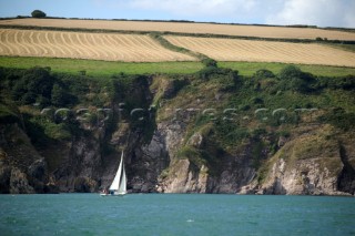 Cruising yacht sailing along the Devon coast