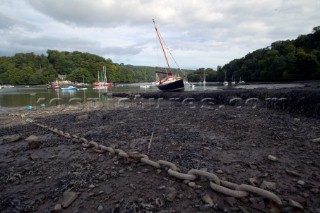 Mooring chain lying on mud at low tide