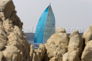 Blue spinnaker behind rocks - Porto Cervo, Sardinia