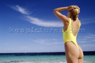 Woman on the beach in yellow swimsuit.