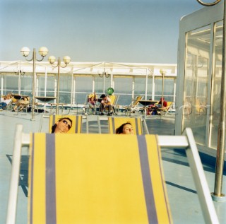 Faces on relaxing on deck chairs