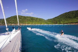 Water skier passing an anchored yacht