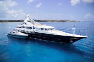 Superyacht at anchor with tenders