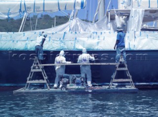 Shipyard workers sparying Awlgrip paint onto the hull of a superyacht