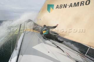 Extreme rough weather sailing shots onboard of the Volvo 70 ABN AMRO surfing downwind with wash, waves and spray on deck testing the teamwork and commitment of the crew