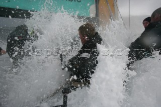 Extreme rough weather sailing shots onboard of the Volvo 70 ABN AMRO surfing downwind with wash, waves and spray on deck testing the teamwork and commitment of the crew