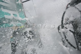 Extreme rough weather sailing shots onboard of the Volvo 70 ABN AMRO surfing downwind with wash, waves and spray on deck testing the teamwork and commitment of the crew