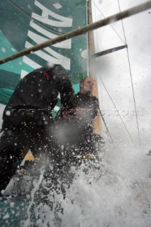 Extreme rough weather sailing shots onboard of the Volvo 70 ABN AMRO surfing downwind with wash, waves and spray on deck testing the teamwork and commitment of the crew