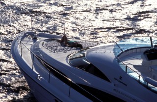 Male and female models relaxing and socialising on a luxury Fairline powerboat