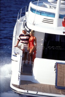 Male and female models relaxing and socialising on a luxury Fairline powerboat